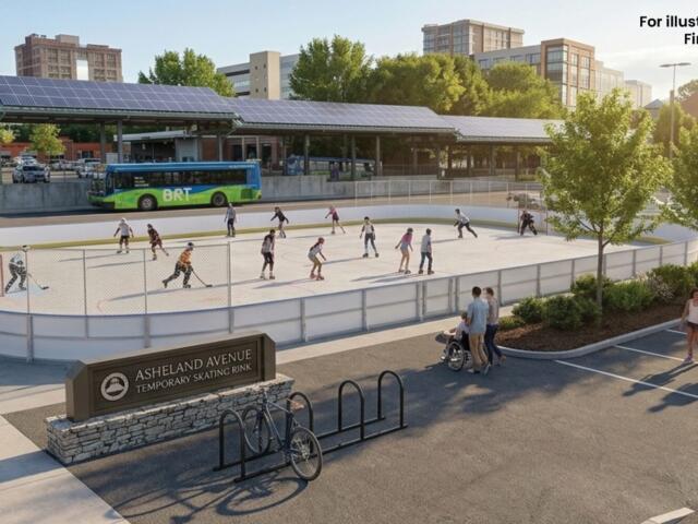 People skate on an outdoor rink surrounded by trees and pedestrians, with a city bus and buildings in the background.