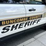 Side view of a Buncombe County Sheriff's Office patrol SUV with emblem and gold stripe on the door edge