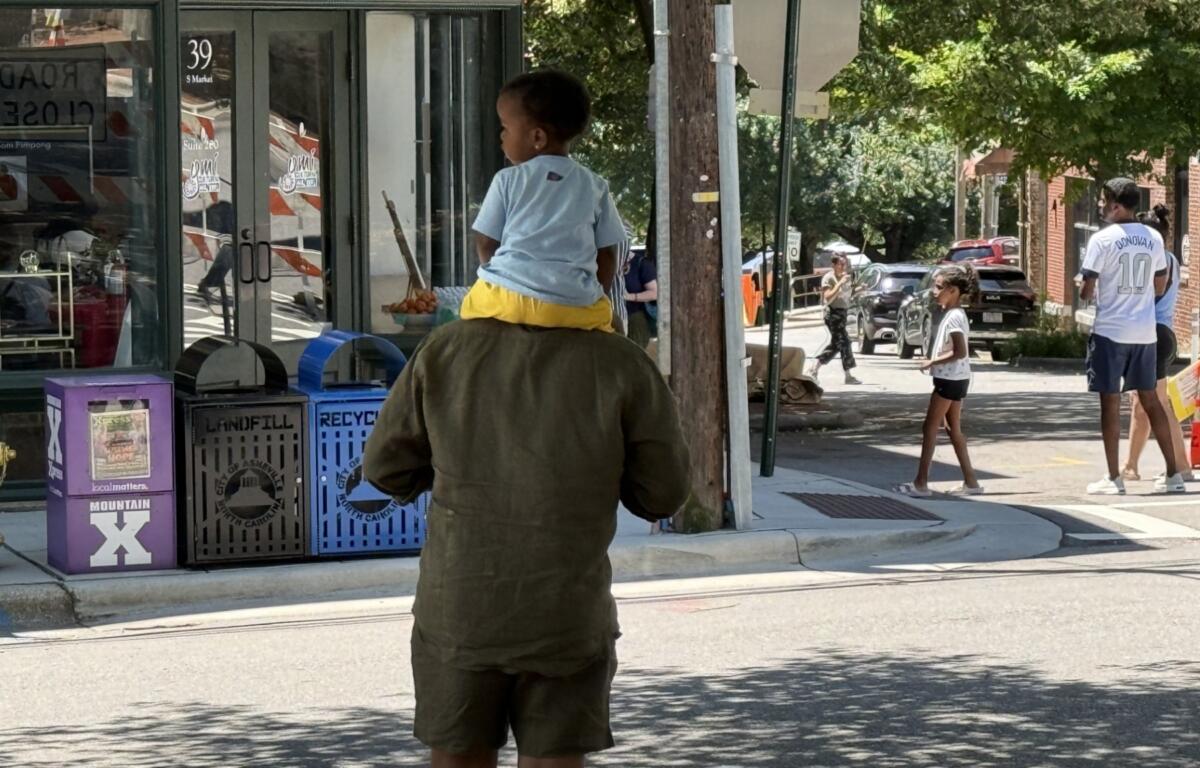 People head to The Block in downtown Asheville as vendors finish setting up for the Juneteenth celebrations taking place Friday.