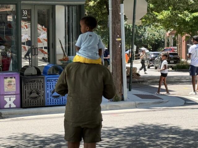 People head to The Block in downtown Asheville as vendors finish setting up for the Juneteenth celebrations taking place Friday.