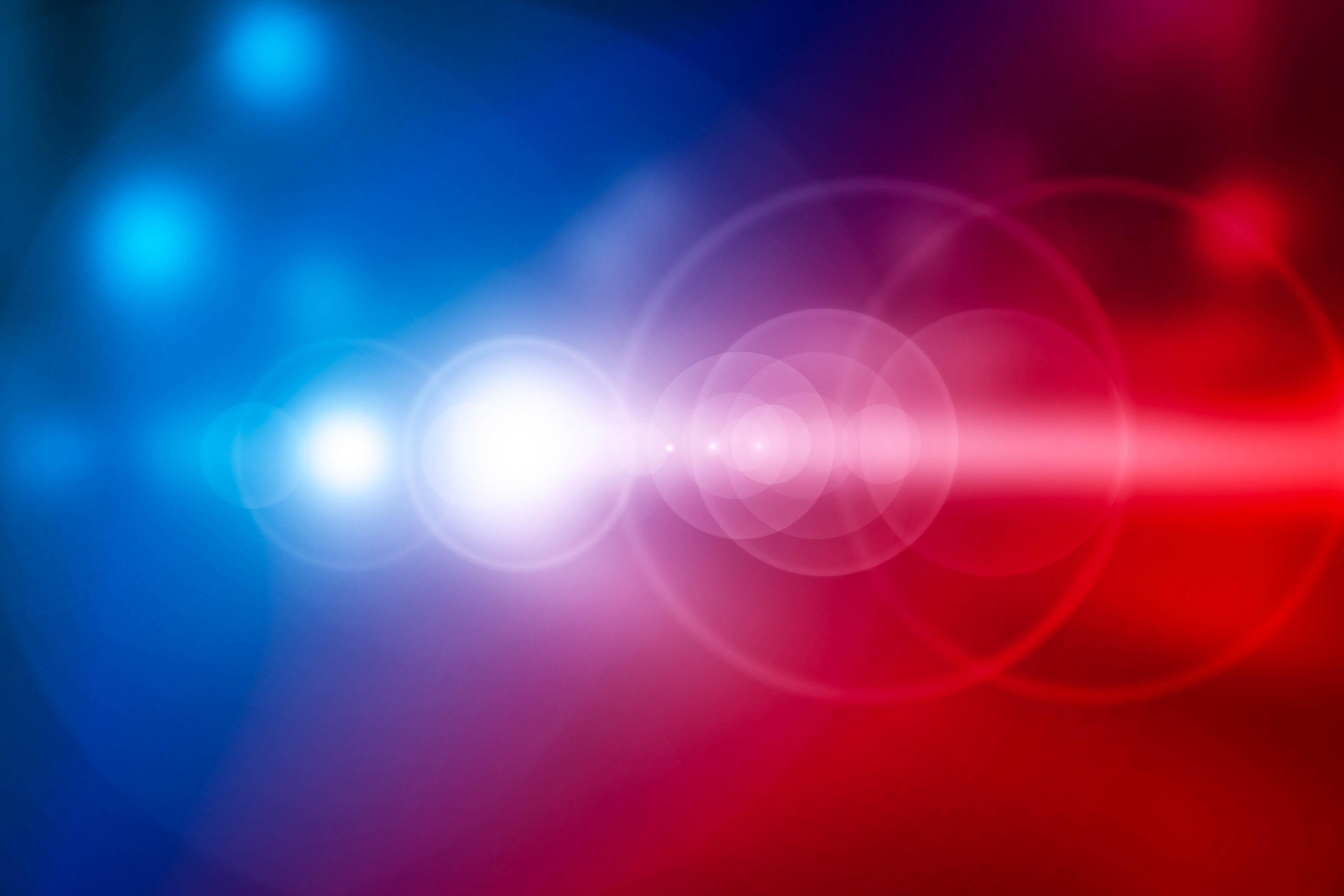 Abstract gradient background transitioning from blue to red with soft white bokeh lights.