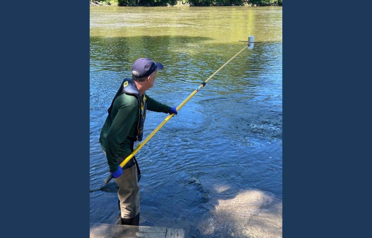 NCDEQ staff collect a water sample from the French Broad River in Asheville as part of the agency's seasonal water quality monitoring program.