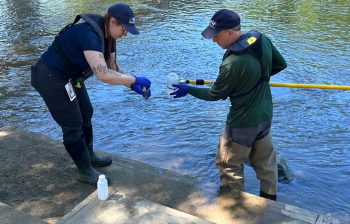 NCDEQ staff collect a water sample from the French Broad River in Asheville as part of the agency's seasonal water quality monitoring program.