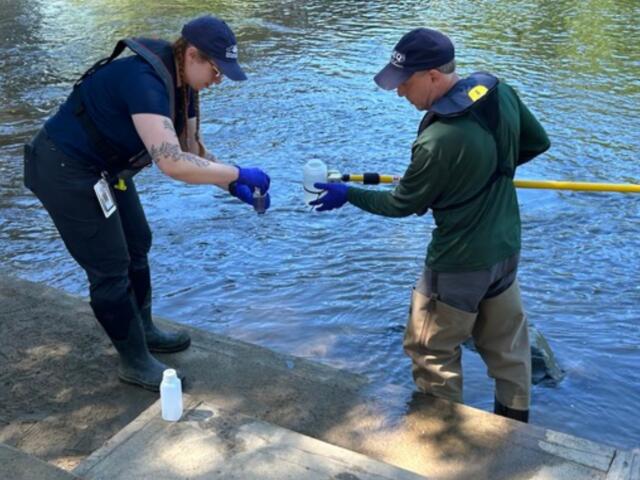 NCDEQ staff collect a water sample from the French Broad River in Asheville as part of the agency's seasonal water quality monitoring program.