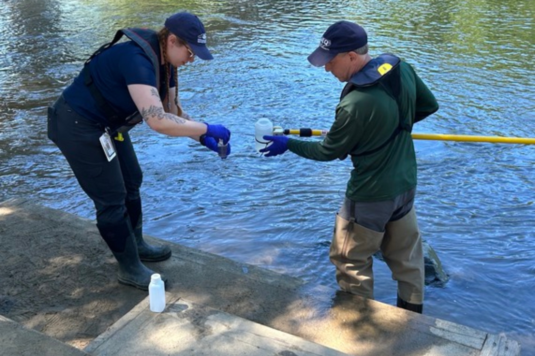 NCDEQ staff collect a water sample from the French Broad River in Asheville as part of the agency's seasonal water quality monitoring program.