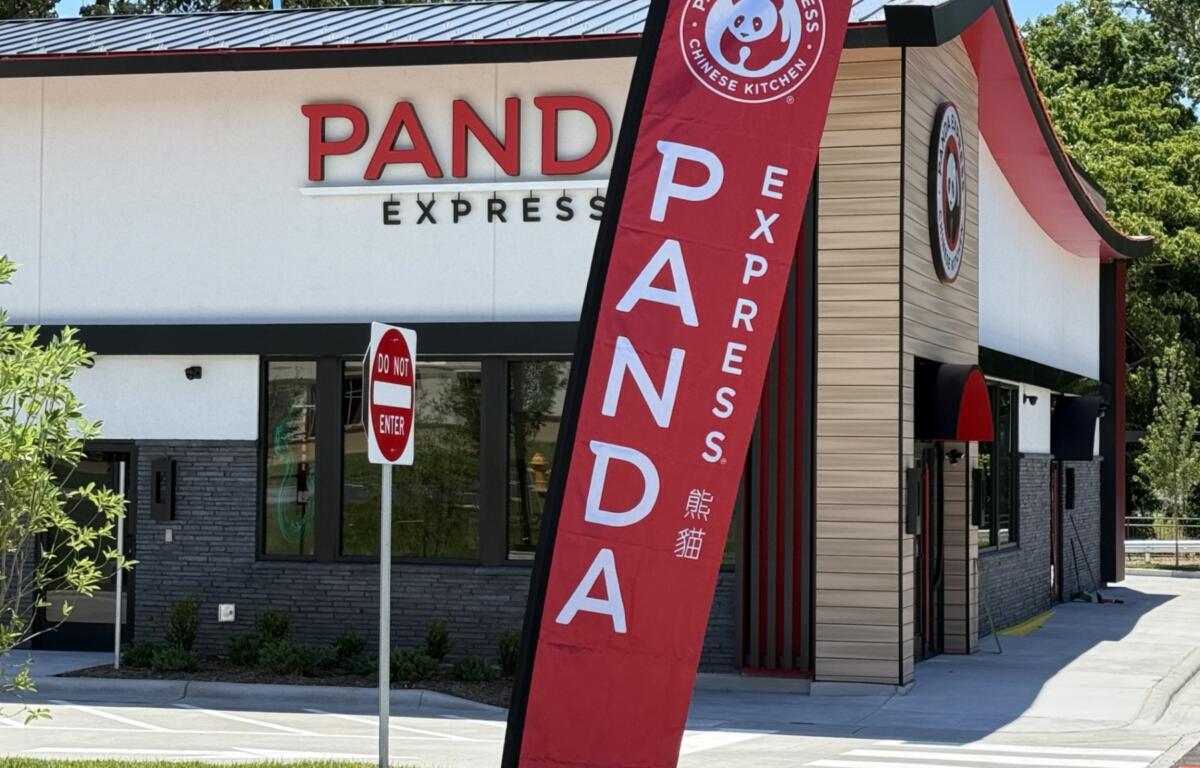 Exterior of a Panda Express restaurant with a large red vertical banner in the foreground and a 'Do Not Enter' sign nearby.