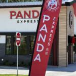Exterior of a Panda Express restaurant with a large red vertical banner in the foreground and a 'Do Not Enter' sign nearby.