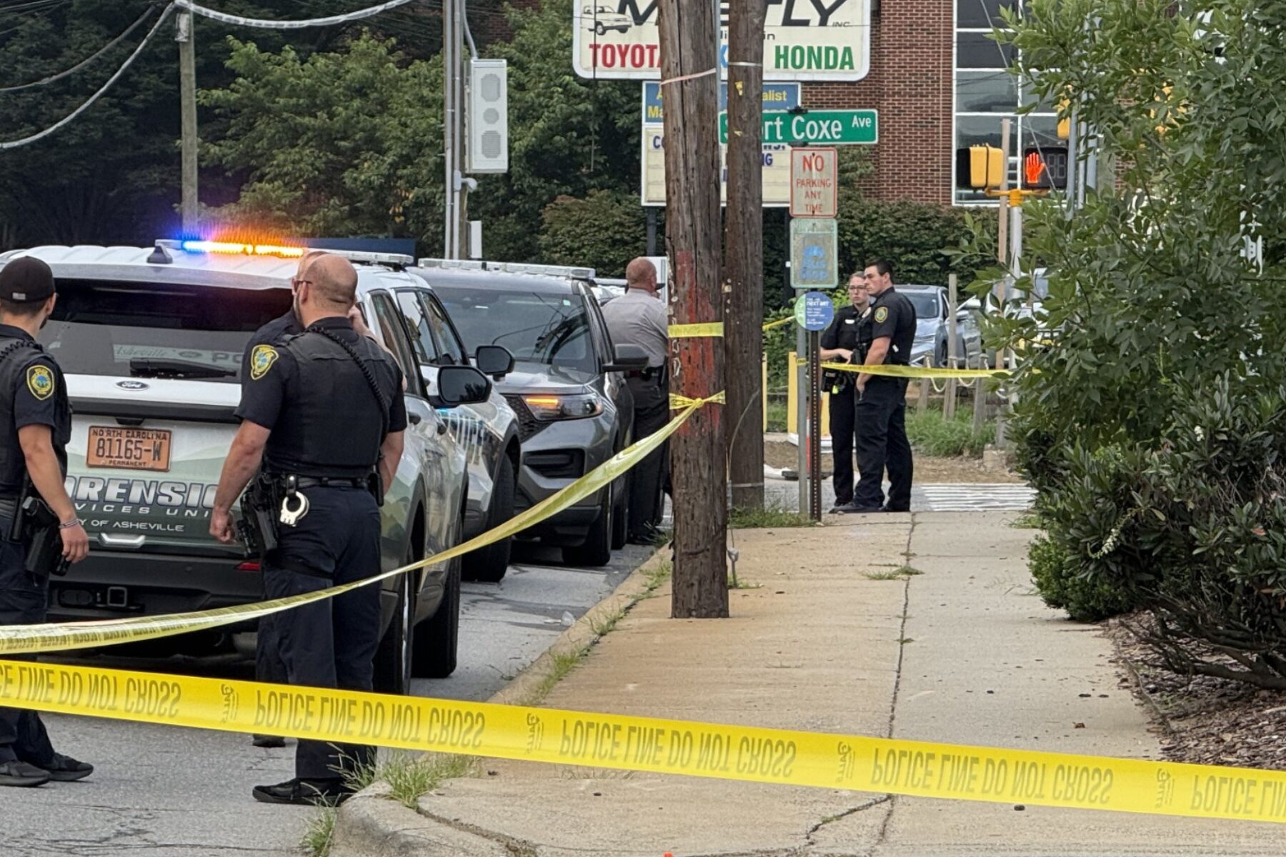 Asheville police officers and forensic investigators process the scene of a deadly shooting along Biltmore Avenue and Short Coxe Avenue early Sunday morning.