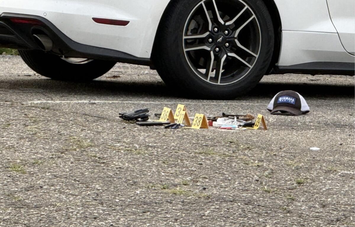 Evidence markers are placed in the parking lot of a business on North French Broad Avenue in downtown Asheville following an early Wednesday officer-involved shooting.