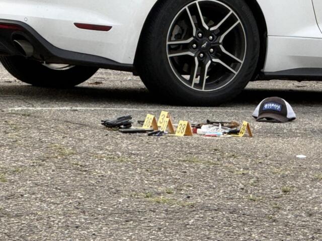 Evidence markers are placed in the parking lot of a business on North French Broad Avenue in downtown Asheville following an early Wednesday officer-involved shooting.