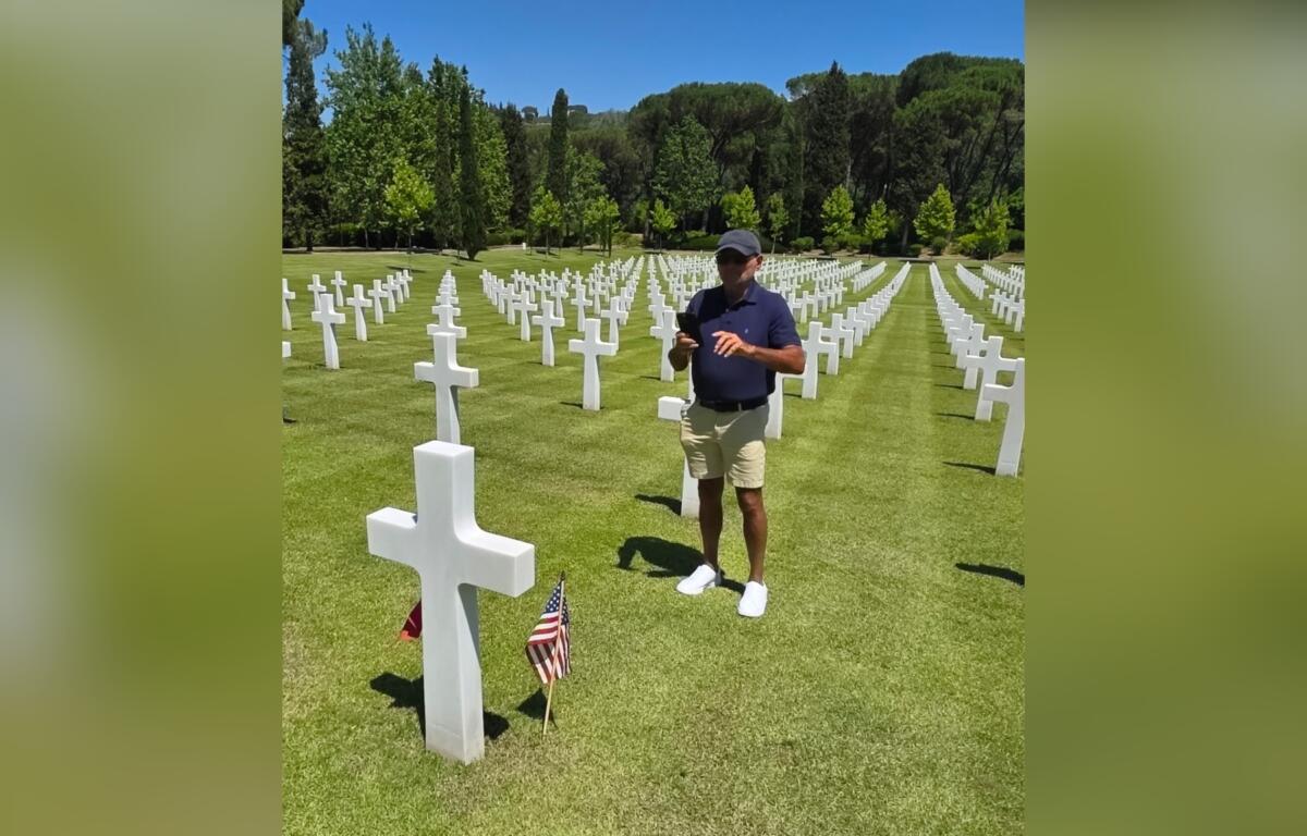 Ted Wilson stands at his Uncle Raymond Wilson's grave