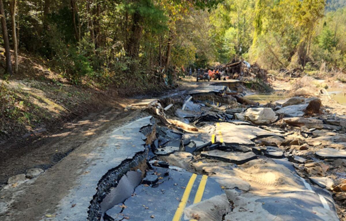A section of Green River Cove Road in Polk County remains heavily damaged following Tropical Storm Helene, with washouts and slope failures visible along the roadway as crews begin long-term reconstruction efforts.
