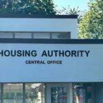 Front of a Housing Authority Central Office building with a bold sign reading 'HOUSING AUTHORITY' and 'CENTRAL OFFICE'.