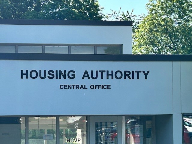 Front of a Housing Authority Central Office building with a bold sign reading 'HOUSING AUTHORITY' and 'CENTRAL OFFICE'.