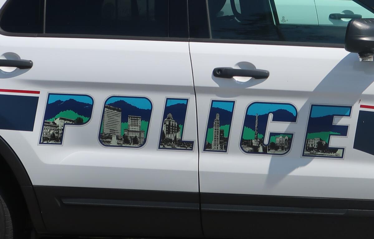 White van side with large, colorfully outlined letters filled with skyline illustrations and mountains.