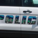 White van side with large, colorfully outlined letters filled with skyline illustrations and mountains.