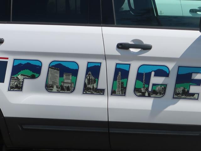 White van side with large, colorfully outlined letters filled with skyline illustrations and mountains.
