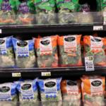 Shelf of Taylor Farms frozen vegetables: broccoli and cauliflower, and broccoli & carrots bags visible on display.