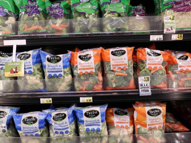 Shelf of Taylor Farms frozen vegetables: broccoli and cauliflower, and broccoli & carrots bags visible on display.