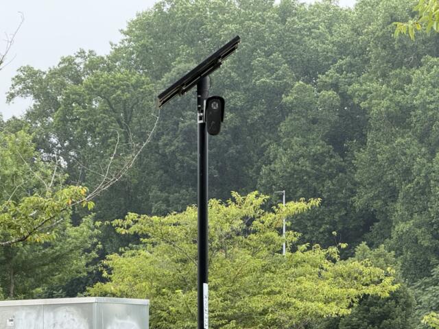 A Flock automated license plate reader camera is seen at the entrance/exit of Lowe's of Smokey Park Highway in Asheville.