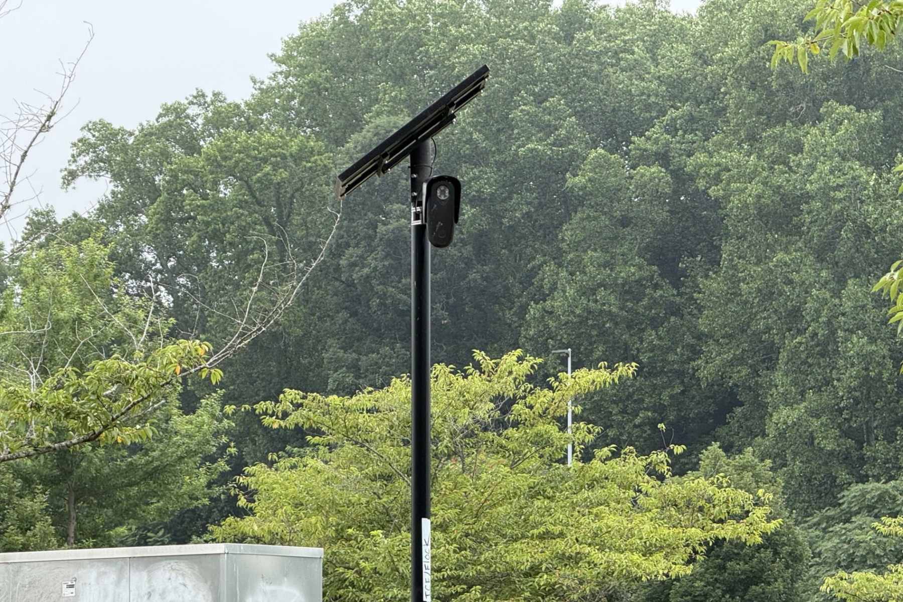 A Flock automated license plate reader camera is seen at the entrance/exit of Lowe's of Smokey Park Highway in Asheville.