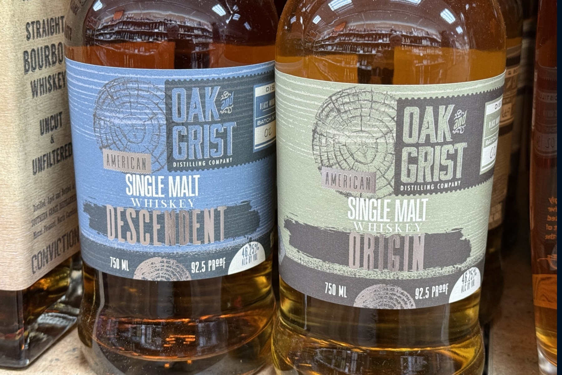 Bottles of Oak & Grist Distilling Co. spirits sit on a shelf at a local retailer. The Black Mountain distillery says it is working to address changes required by town officials related to whiskey barrel storage.