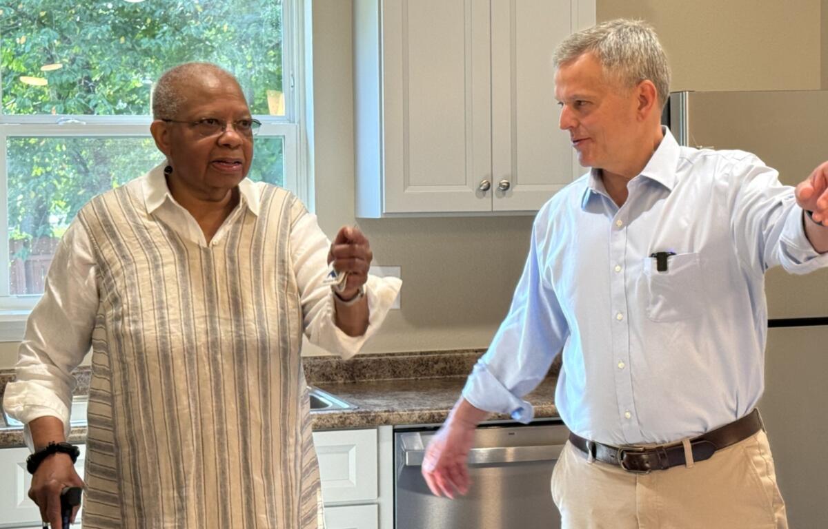 Gov. Josh Stein walks with Velma Chapman as she tours her new Asheville home Wednesday after receiving the keys to the house rebuilt through the Renew NC Single-Family Housing Program.