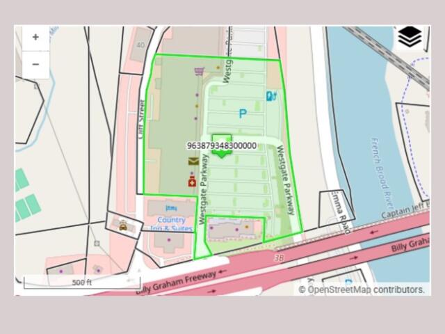 OpenStreetMap-style map with a bright green polygon outlining a block along Westgate Park, near a river and the Billy Graham Freeway; shows a parking area and nearby amenities.