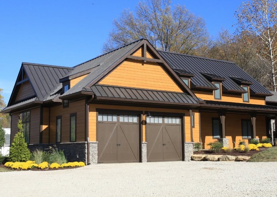Home with a dark standing-seam metal roof and warm-toned siding.