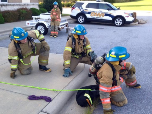Participants in past Asheville Fire Department Explorer programs take part in hands-on firefighting training.