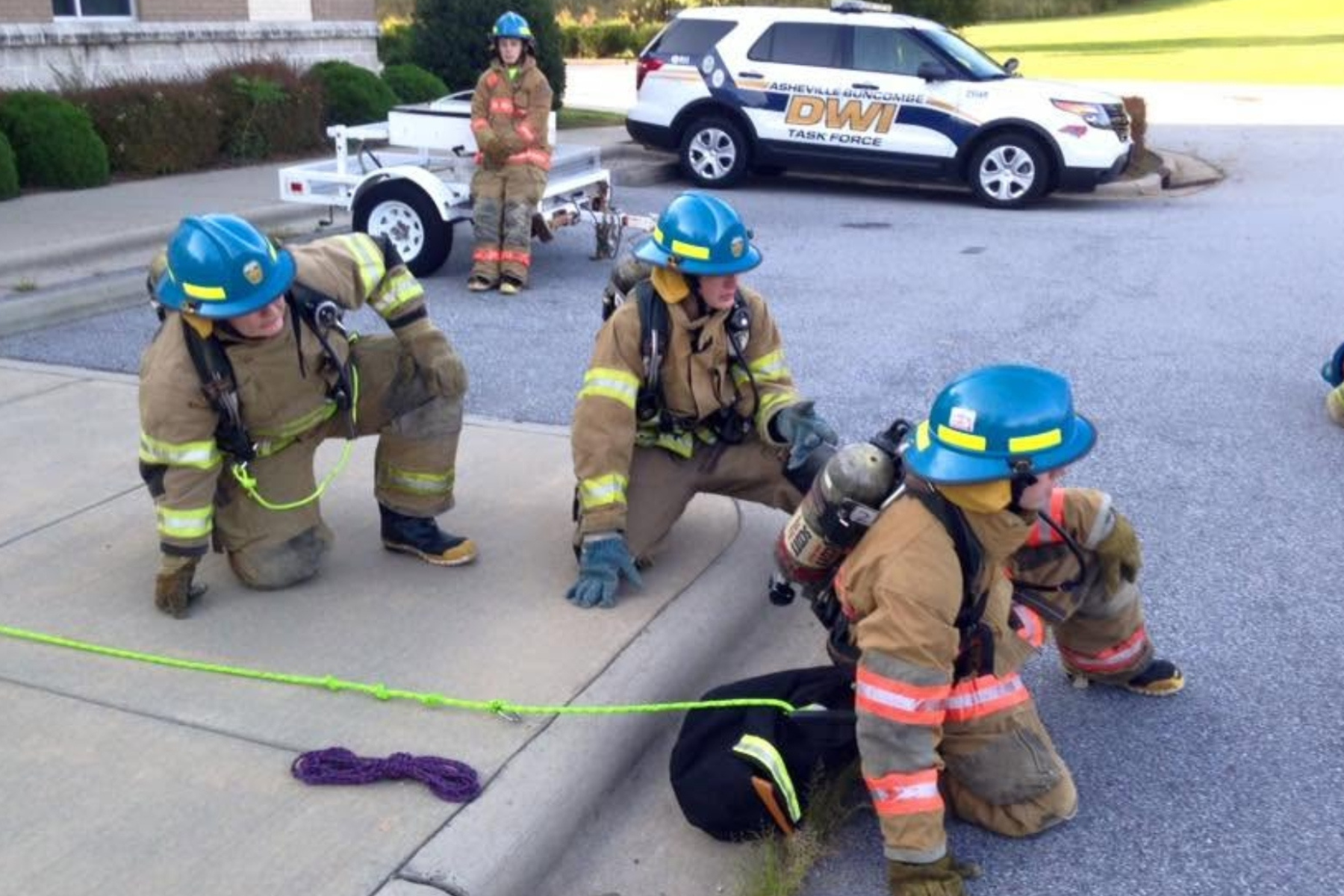 Participants in past Asheville Fire Department Explorer programs take part in hands-on firefighting training.