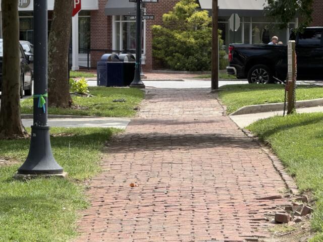 A brick sidewalk along Kitchin Place near Boston Way in Biltmore Village shows signs of wear following Tropical Storm Helene. Asheville is planning repairs to sidewalks, curbs, trees and other infrastructure in the historic district.