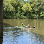 Two fishermen paddle beneath the Craven Street Bridge over the French Broad River as construction continues on the I-26 Connector project in Asheville.