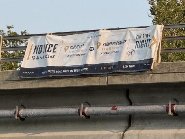 A sign on the Craven Street Bridge provides directions for river users as construction begins in the French Broad River for the I-26 Connector project.