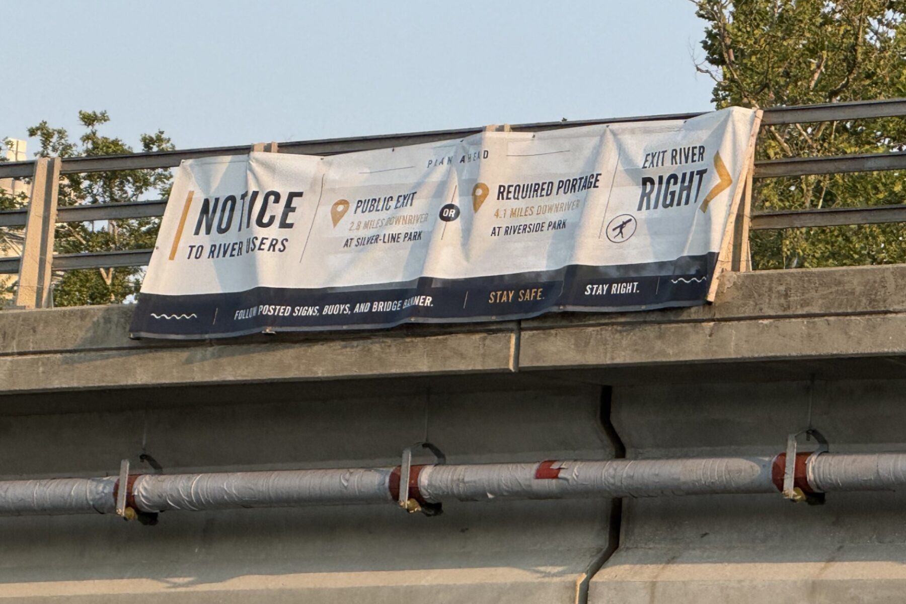 A sign on the Craven Street Bridge provides directions for river users as construction begins in the French Broad River for the I-26 Connector project.