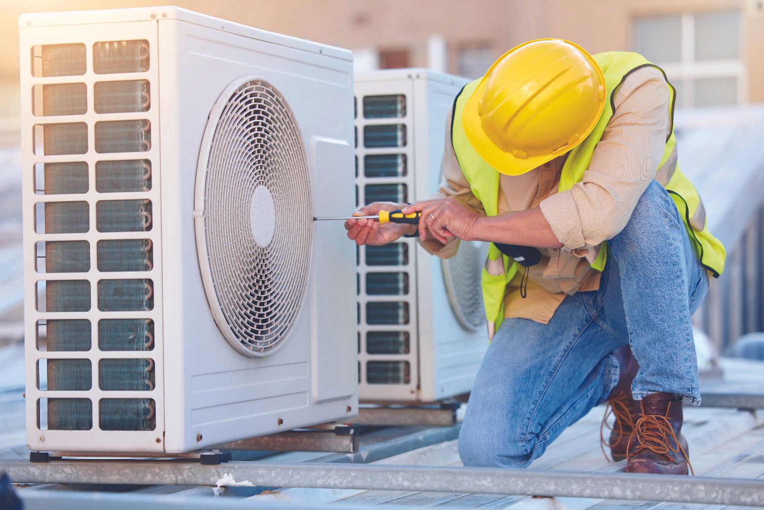HVAC technician performing maintenance on an outdoor air conditioning unit.