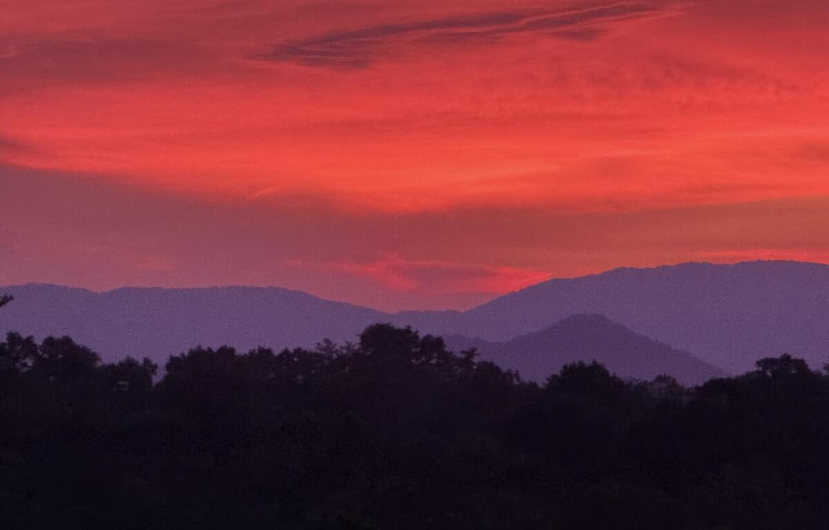 The sun sets over the Blue Ridge Mountains near Asheville, adding to the peaceful scenery that draws visitors to the region.