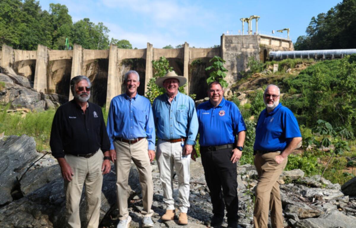 From left: Polk County Commission Chairman Myron Yoder, DEQ Secretary Reid Wilson, DEMLR Director Toby Vinson, Polk County Emergency Management Director Bobby Arledge and Polk County Manager Marche Pittman pose in front of the Turner Shoals Dam, which received $1.3 million to repair damage from Hurricane Helene.