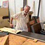 French Broad Exchange owner Jamey Smith paints bookshelves in the back of his store.