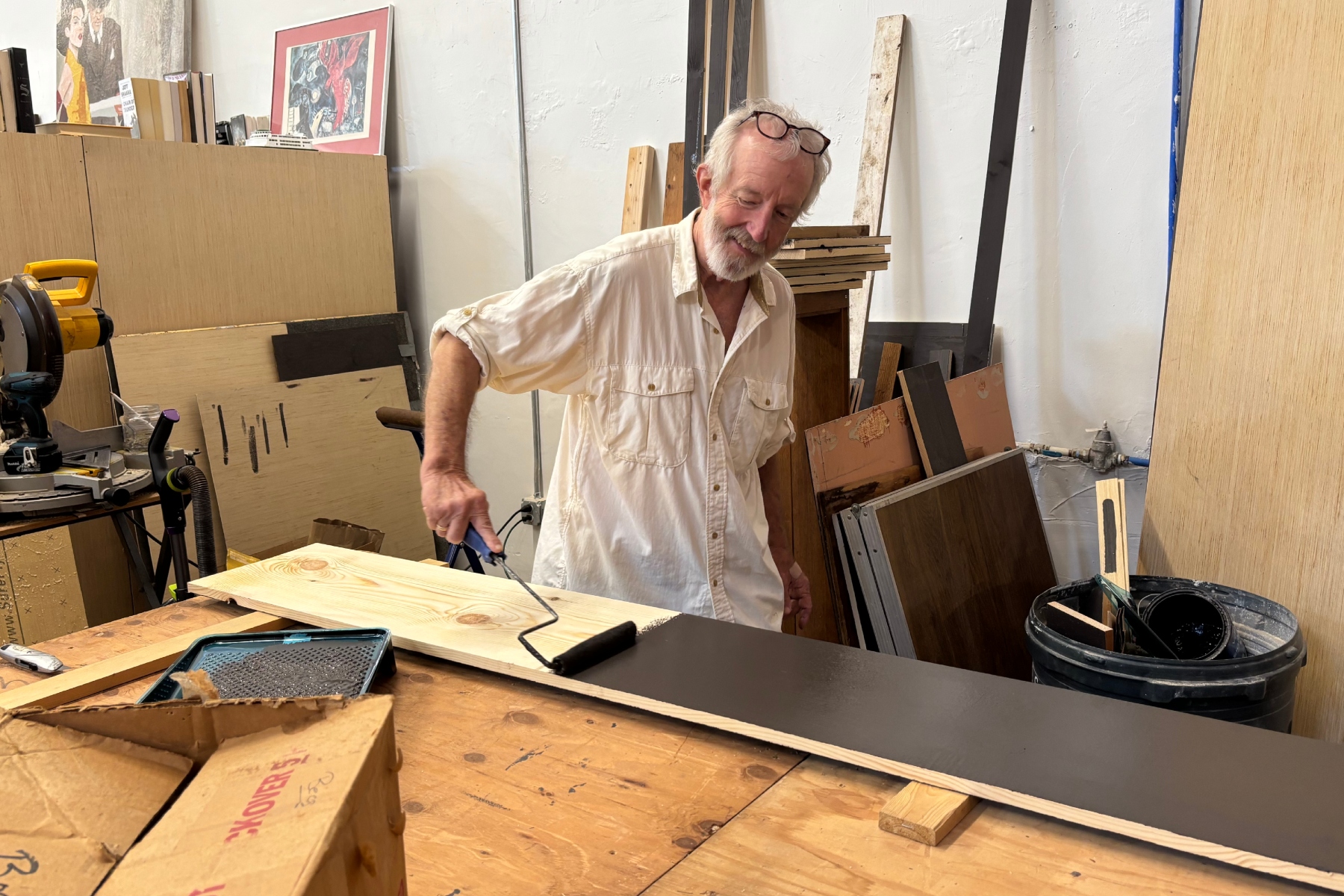 French Broad Exchange owner Jamey Smith paints bookshelves in the back of his store.