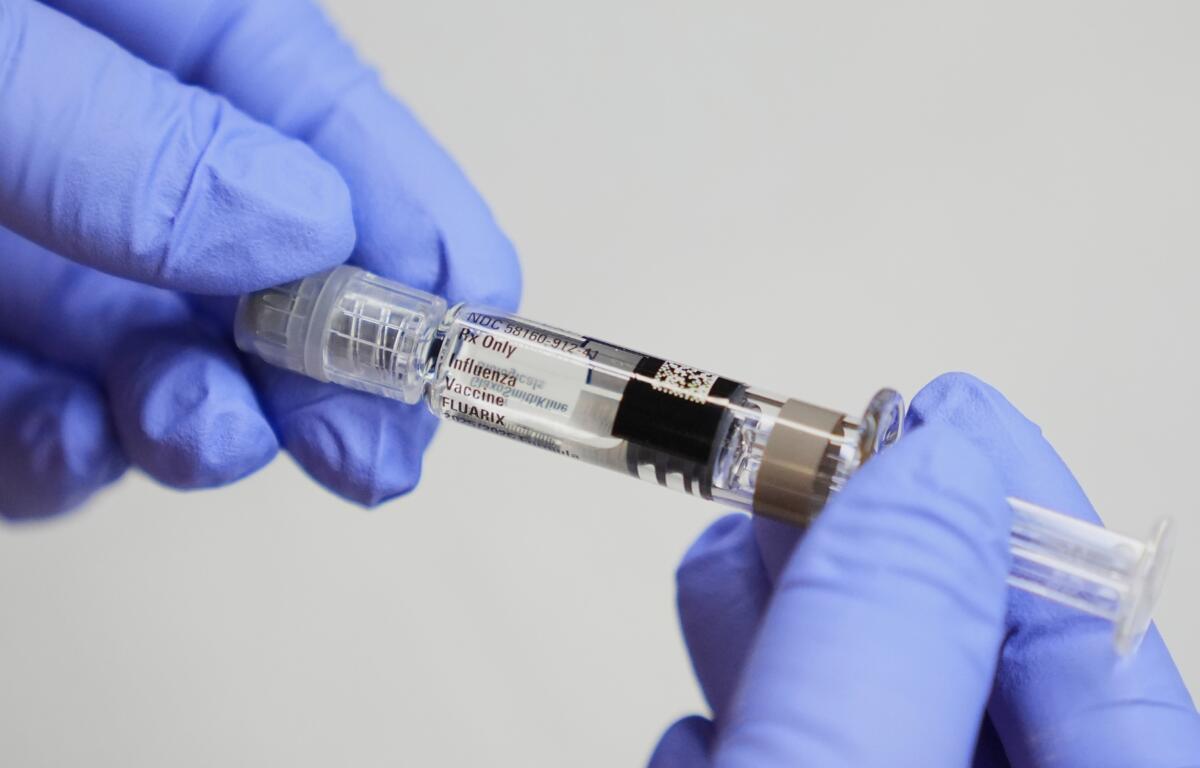 FILE - A certified medical assistant holds a syringe for a flu vaccine at a clinic in Seattle, on Sept. 10, 2025. (AP Photo/Lindsey Wasson, File)