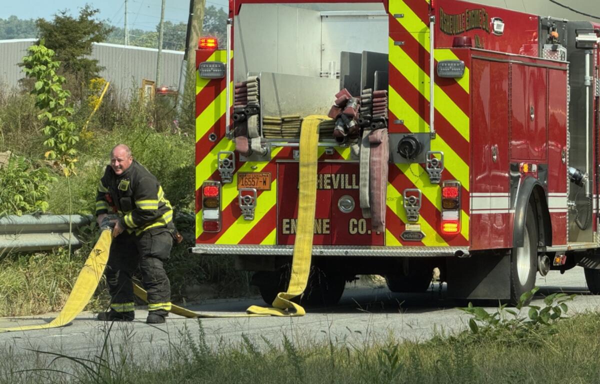 An Asheville firefighter works at the scene of a fire on Riverside Drive. The Asheville Fire Department says I-26 Connector construction has forced crews responding in the Hill Street and Riverside Drive area to adjust their routes.