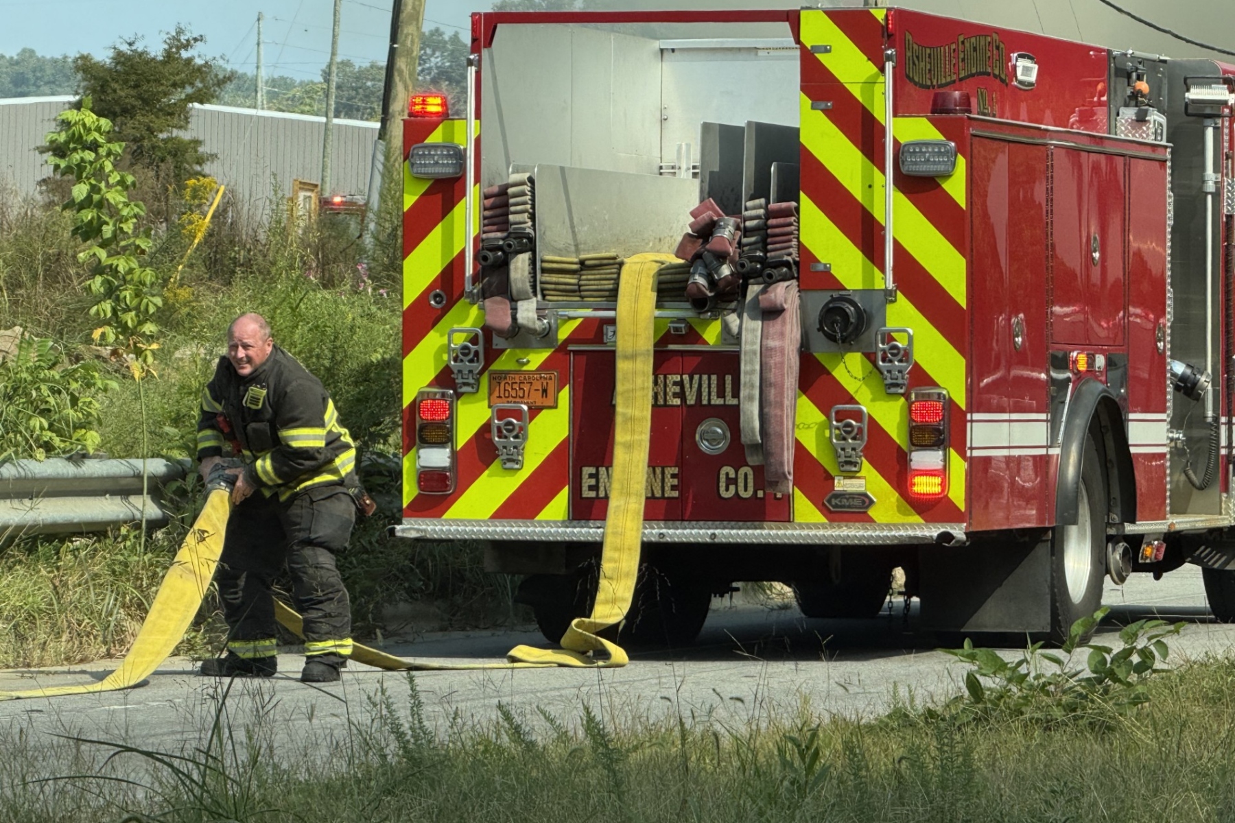 An Asheville firefighter works at the scene of a fire on Riverside Drive. The Asheville Fire Department says I-26 Connector construction has forced crews responding in the Hill Street and Riverside Drive area to adjust their routes.