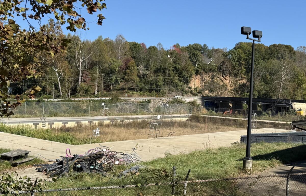 The swimming pool at Asheville's Recreation Park remains closed, with overgrown vegetation and debris visible in the facility. The city received nearly $2.5 million in an earlier round of state grants to help reconstruct the park following Hurricane Helene.