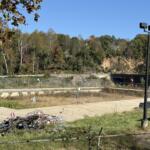 The swimming pool at Asheville's Recreation Park remains closed, with overgrown vegetation and debris visible in the facility. The city received nearly $2.5 million in an earlier round of state grants to help reconstruct the park following Hurricane Helene.