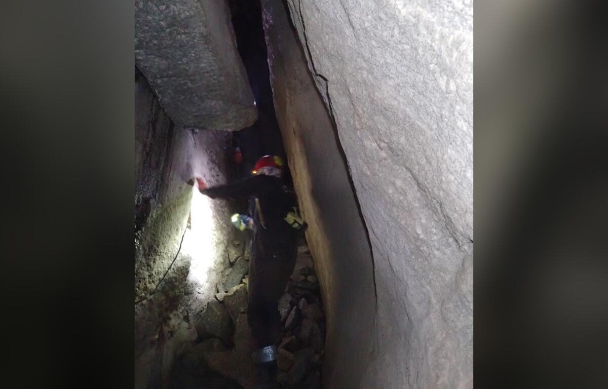 Explorers navigate a narrow passage between towering rock walls inside Bat Cave in Henderson County. The cave, known for its unusual geological formations and legends of buried treasure, is protected by The Nature Conservancy and closed to the public. (Photo by Sue Cameron/U.S. Fish and Wildlife Service)