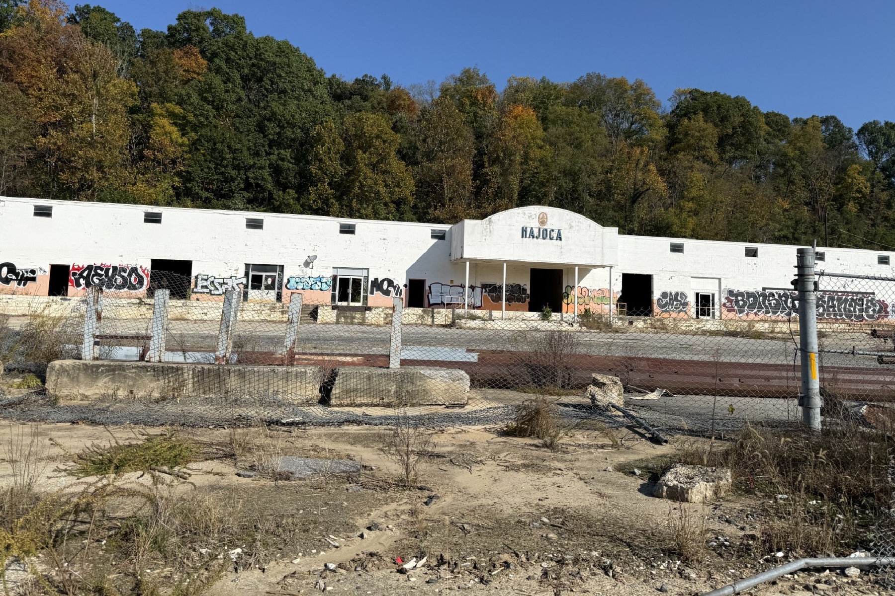 An overgrown property along Swannanoa River Road in Asheville is part of the site proposed for a 524-unit apartment development. The project has raised concerns among city design reviewers about flooding and emergency evacuation routes.