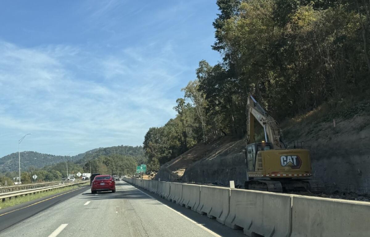 Construction equipment works along a cut slope beside I-26 in Asheville as crews continue work on the I-26 Connector project. Overnight lane closures are planned next week near the Broadway interchange as crews haul rock from the construction area.