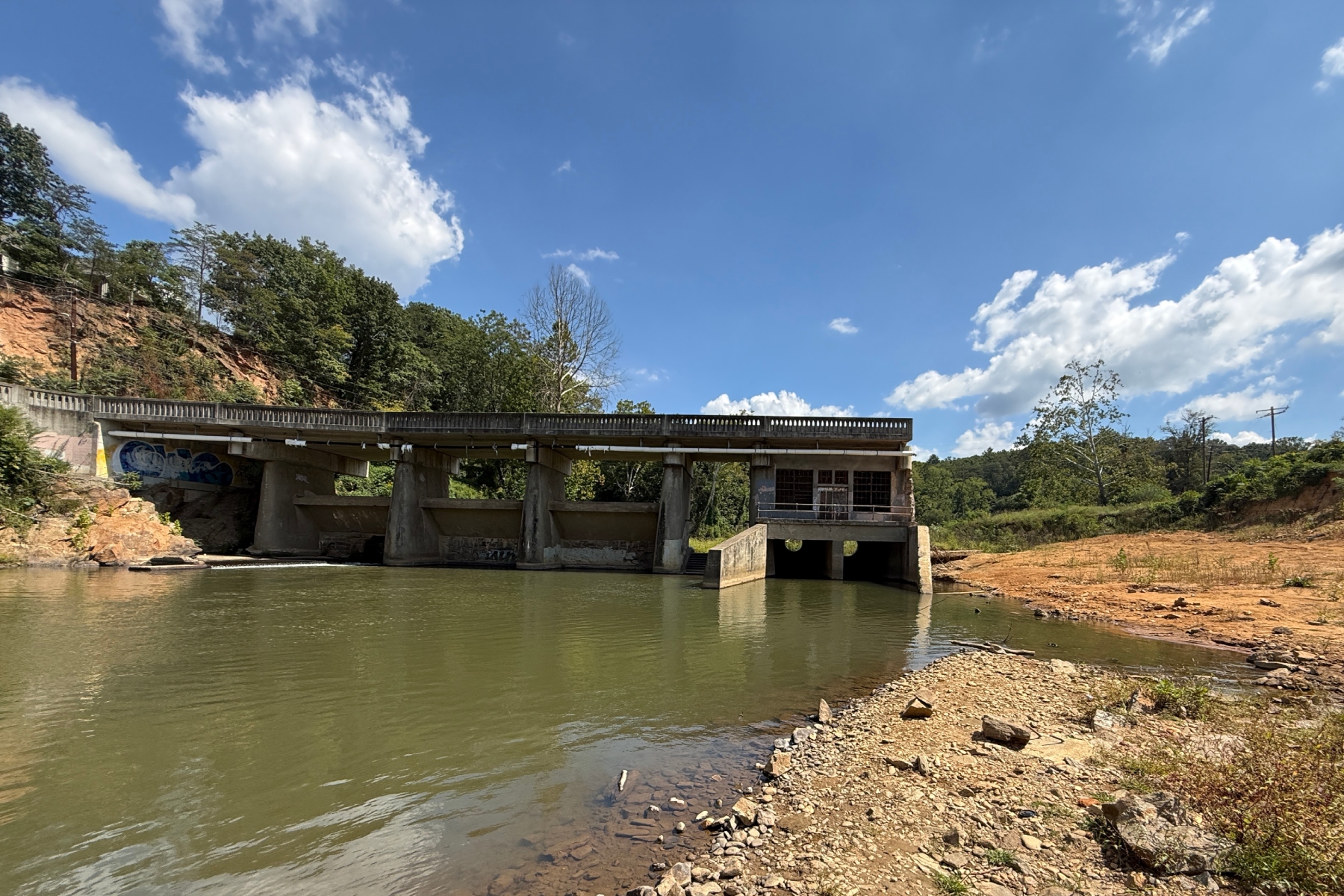 Lake Craig Dam spans the Swannanoa River in Asheville. Hurricane Helene partially washed out the century-old dam, creating an opening that has allowed fish to reach upstream habitat that had been blocked for more than 100 years.