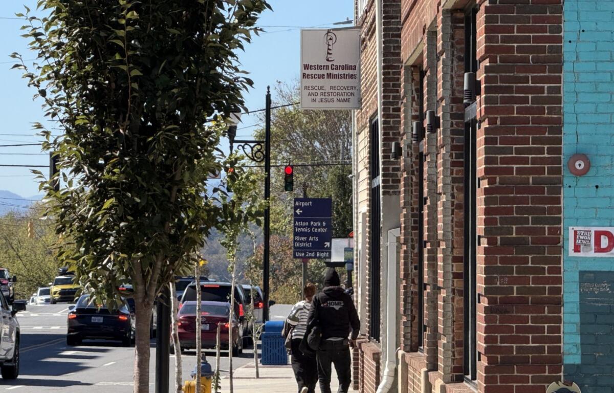 Pedestrians walk past Western Carolina Rescue Ministries in downtown Asheville.
